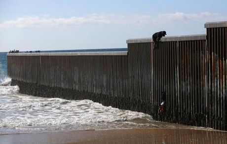 تصویر غم‌انگیز یک پناهجو در حال عبور از مانع مرزی بین مکزیک و آمریکا