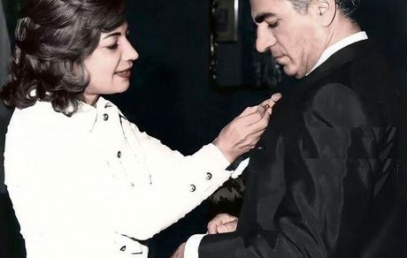 عکسی زیر خاکی از اشرف پهلوی در حال نصب مدال بر سینه برادر دو قلویش