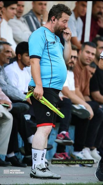 تصویری از پرچم زدن کمک داور فینال محلات در حال استعمال سیگار 